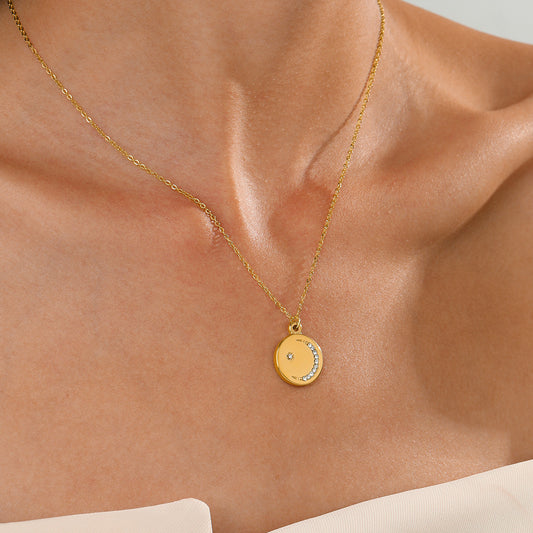 Gold necklace with a pendant on a person's neck