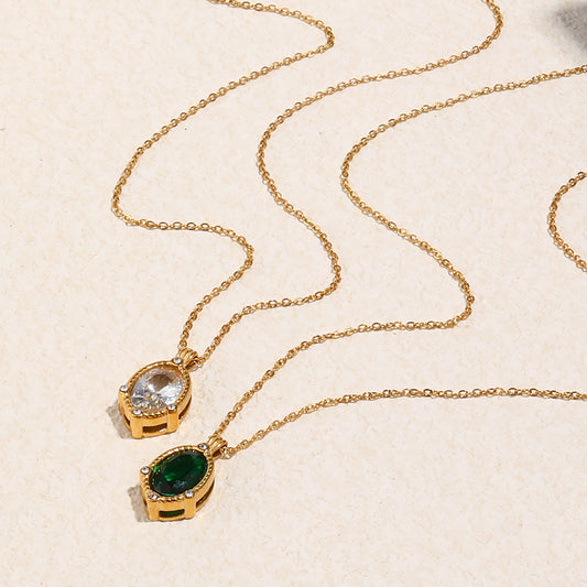 Gold necklaces with gemstone pendants on a beige background