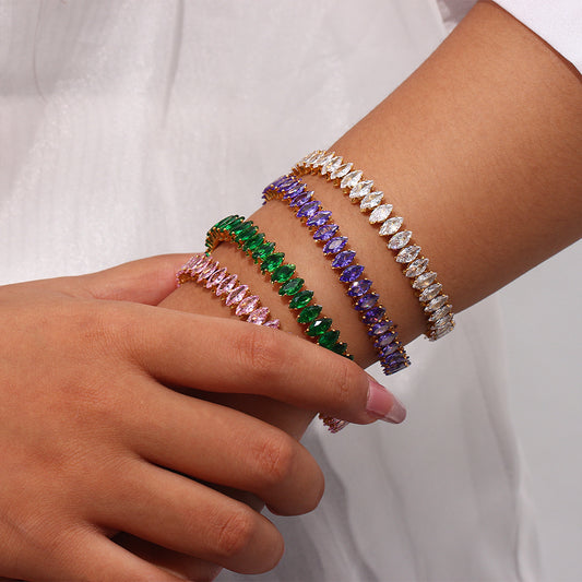 Close-up of a wrist wearing multiple colorful beaded bracelets on a plain background