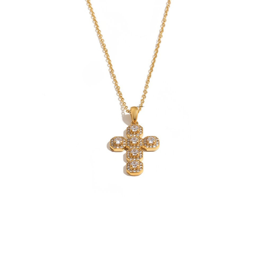 A gold cross pendant necklace adorned with small clear stones, suspended from a delicate gold chain against a plain white background.