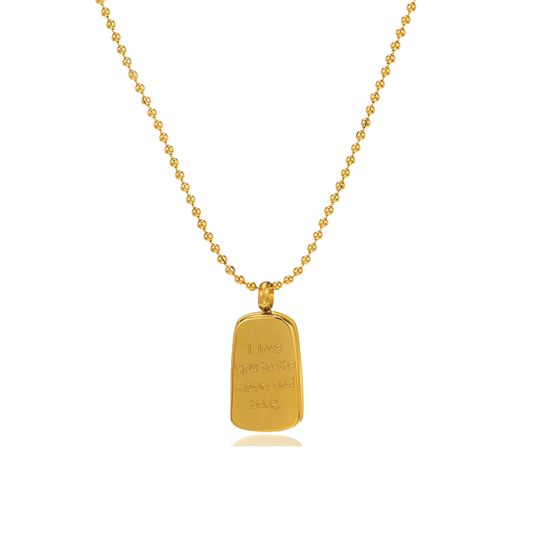 A gold ball-chain necklace with a polished gold rectangular pendant engraved with the words 'I love to the moon and back' on a clean white background.