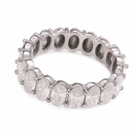 A silver-toned eternity ring featuring a continuous row of oval-cut clear gemstones in a prong setting, shown on a plain white background.