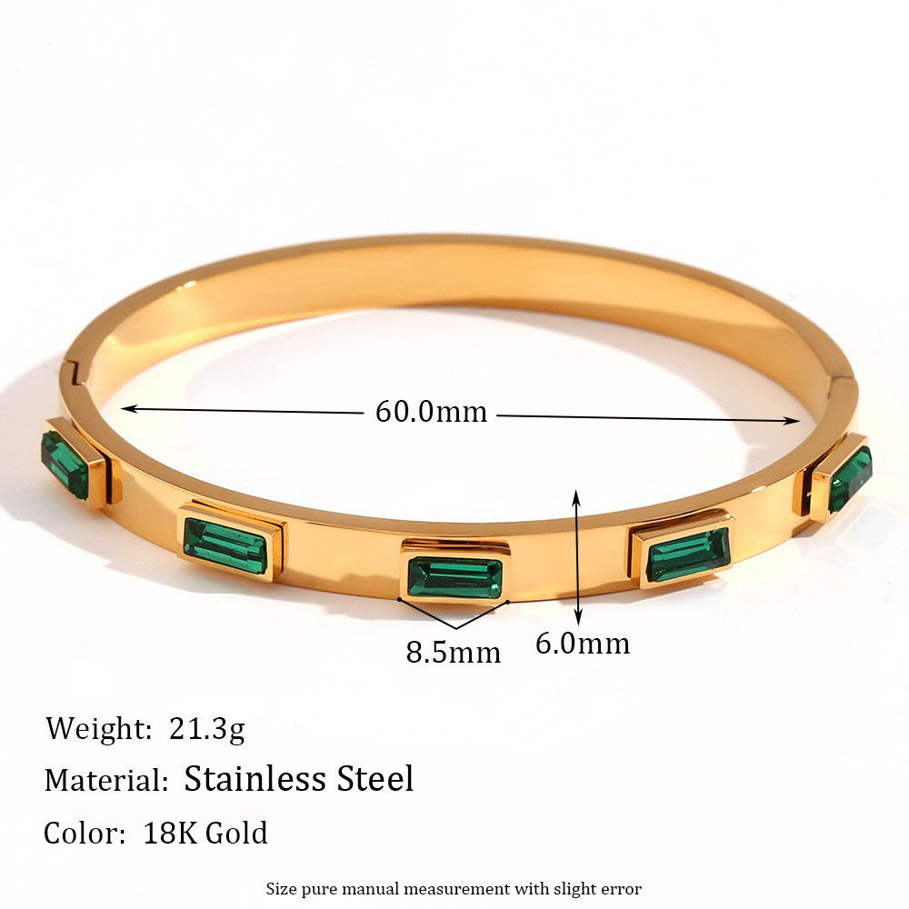 Gold bracelet with green gemstones and measurement details on a white background