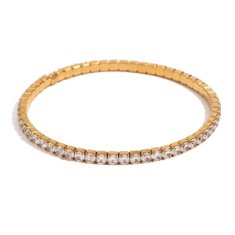 Gold bracelet with diamond accents on a white background