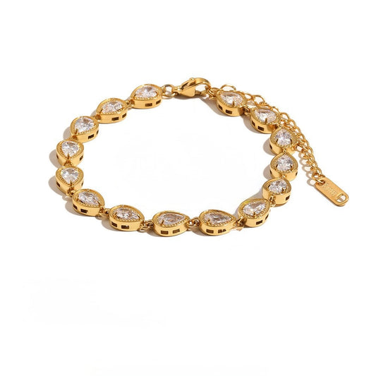 A gold bracelet featuring a series of teardrop-shaped clear gemstones in gold settings, displayed on a clean white background.