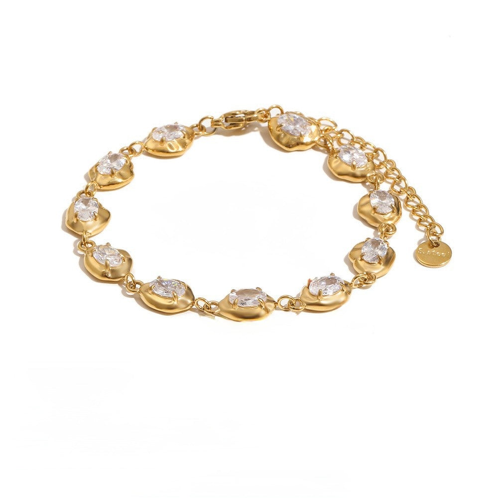 A gold chain bracelet with multiple oval links set with clear round gemstones, displayed on a clean white background.