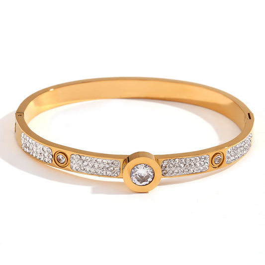 Gold Bangle with diamond accents on a white background