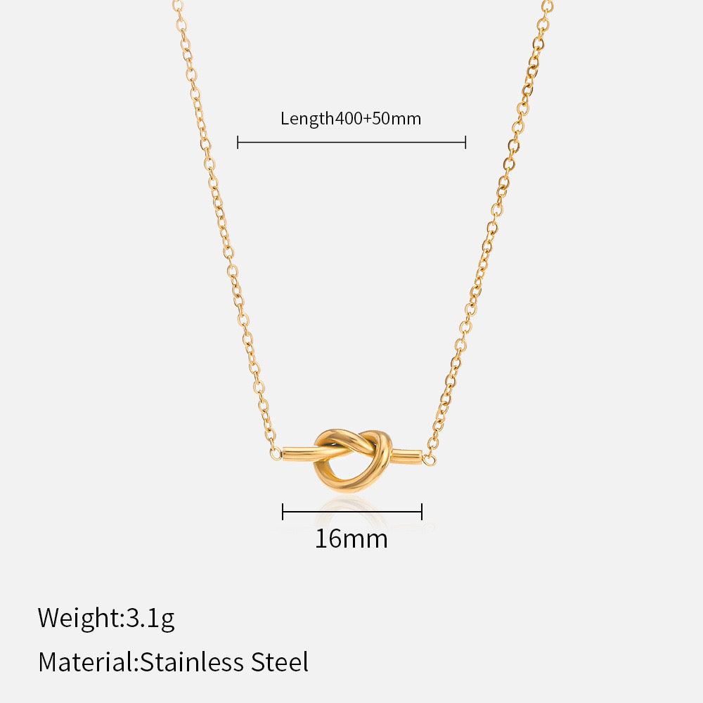 Gold necklace with knot pendant on a white background