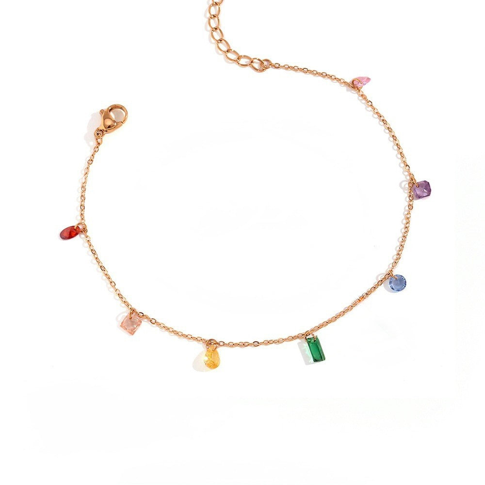 A delicate gold chain bracelet featuring multiple small, colorful gemstone charms in various shapes, displayed on a clean white background.