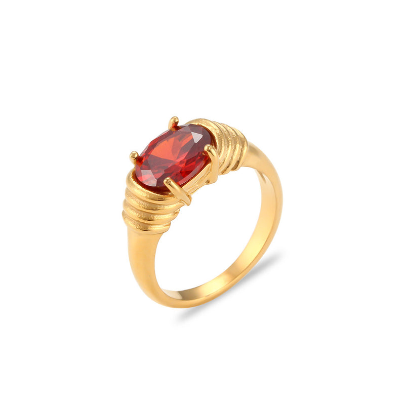 Gold ring with a red gemstone on a white background
