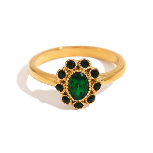 Gold ring with a green gemstone on a white background