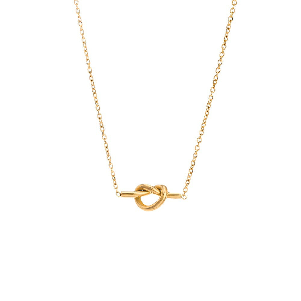 A delicate gold chain necklace featuring a central knot pendant suspended on a horizontal bar, presented on a clean white background.