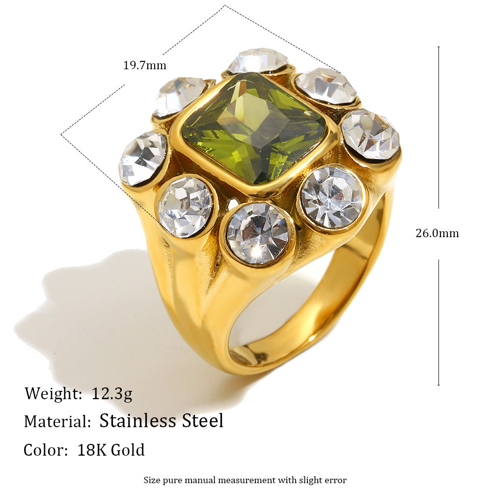 Gold ring with green gemstone and clear stones, showing measurements and material details.