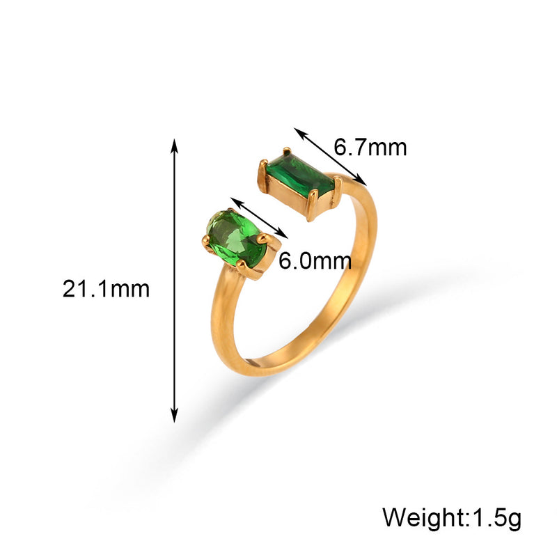 Gold ring with green gemstones and measurements on a white background