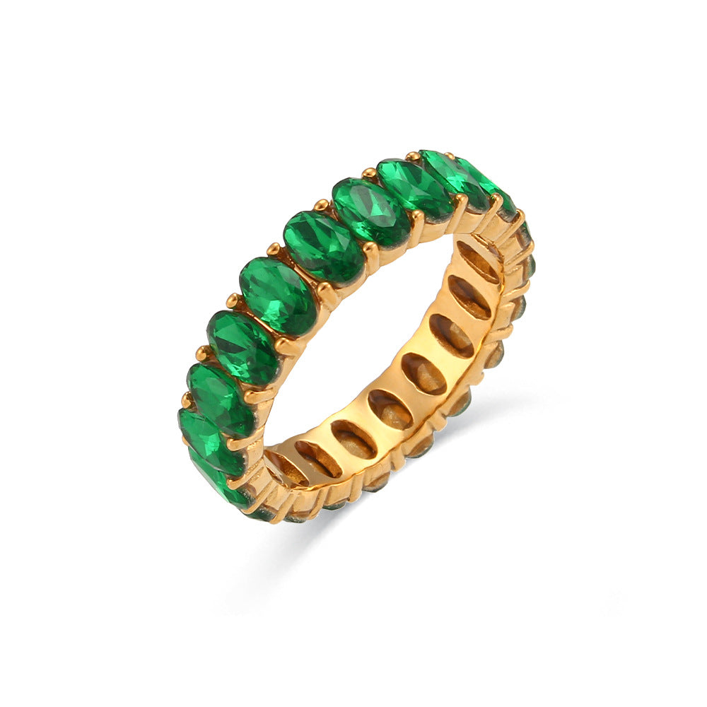 Gold ring with green gemstones on a white background