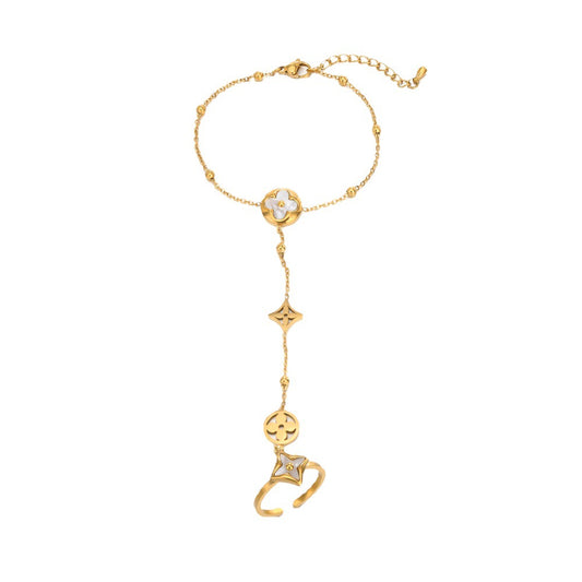 A gold-toned chain bracelet featuring a clover motif with a clear crystal, a dangling star charm, and a stylized cat-shaped charm, displayed on a solid white background.