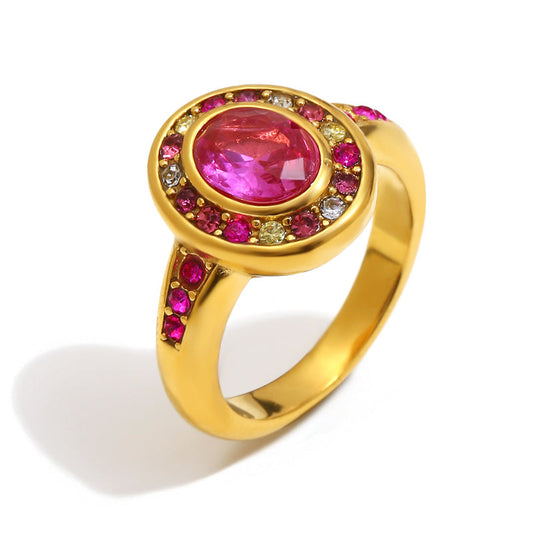 Gold ring with a pink gemstone and colorful accents on a white background