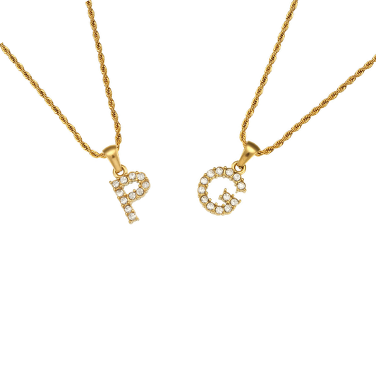Two gold rope-chain necklaces with initial letter pendants, one reading 'P' and the other 'G', both set with small clear stones, on a plain white background.