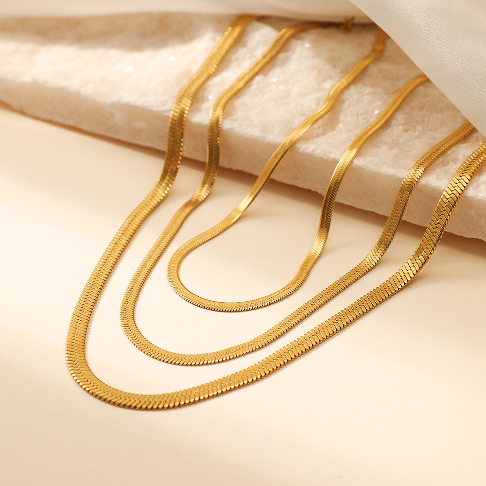 Gold chains on a textured beige surface