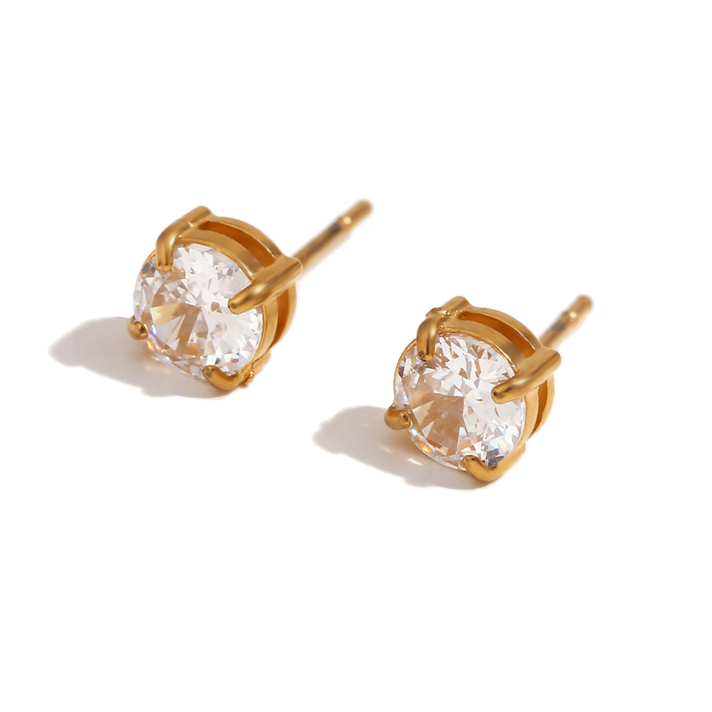 Gold stud earrings with clear gemstones on a white background