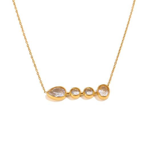 A gold chain necklace with a horizontal bar pendant featuring a large teardrop-shaped clear gemstone and three smaller round clear gemstones in gold bezels, set against a plain white background.