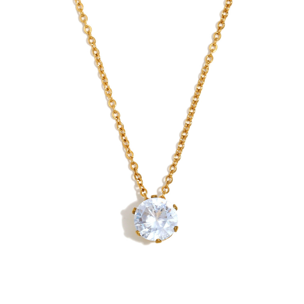 Gold necklace with a clear gemstone pendant on a white background
