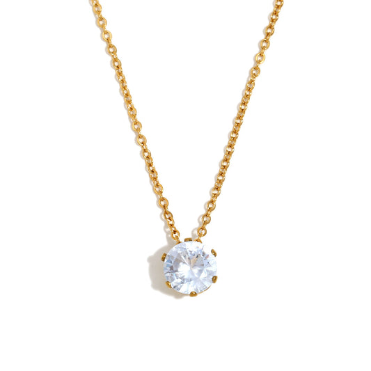 Gold necklace with a clear gemstone pendant on a white background
